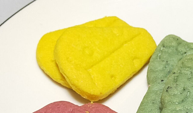 丸いチーズからケーキのように切り出した形をかたどった、ヴォヤージュサブレのチーズ味の写真